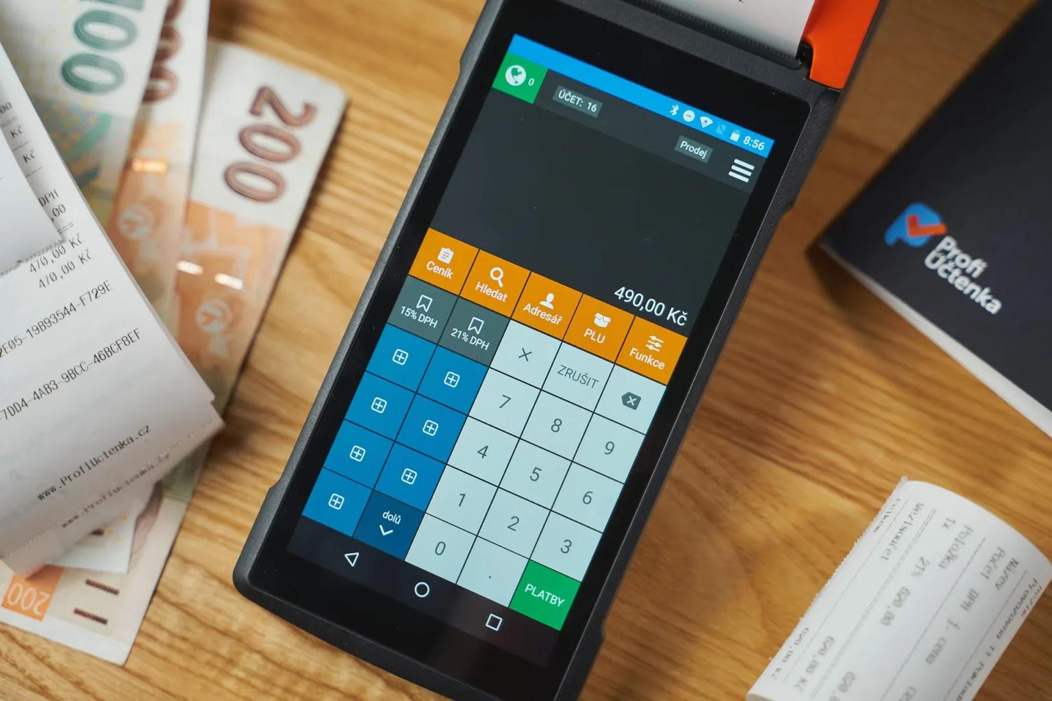 Платіжний термінал з грошима та чеками на столі