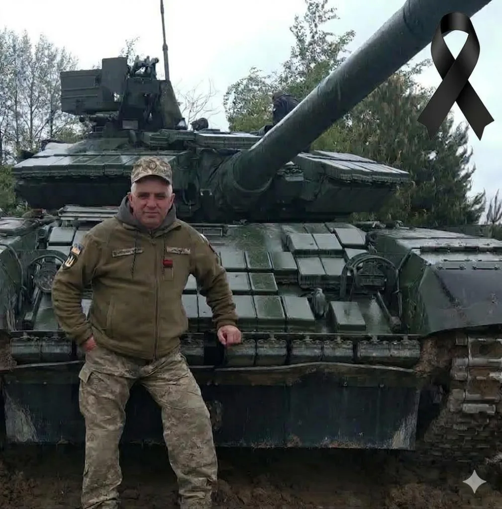 Військовий стоїть перед танком на вулиці