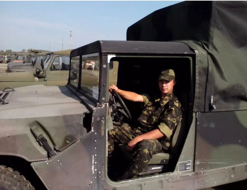 Військовий у камуфляжі сидить у військовій машині