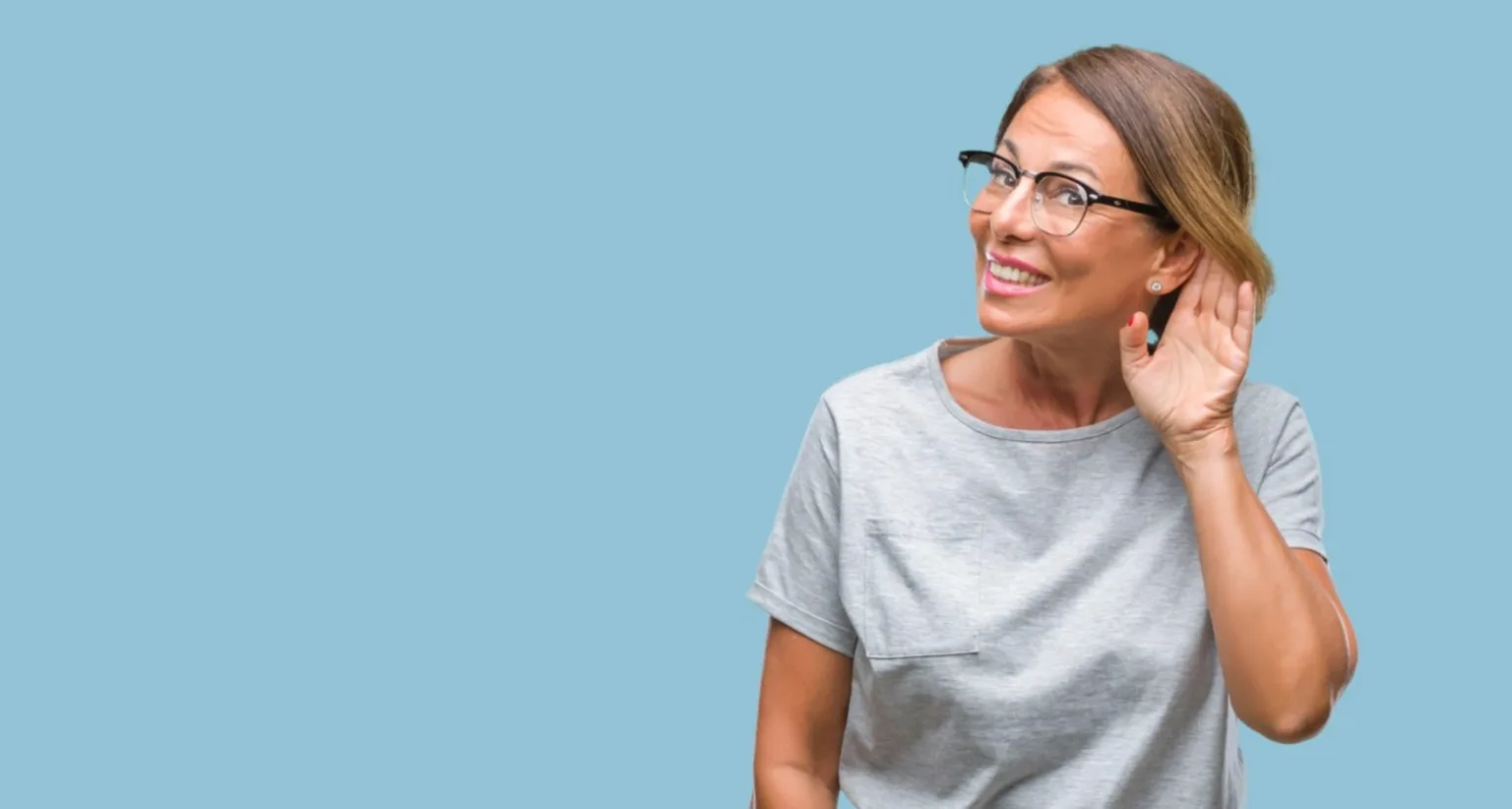 Жінка слухає, приклавши руку до вуха