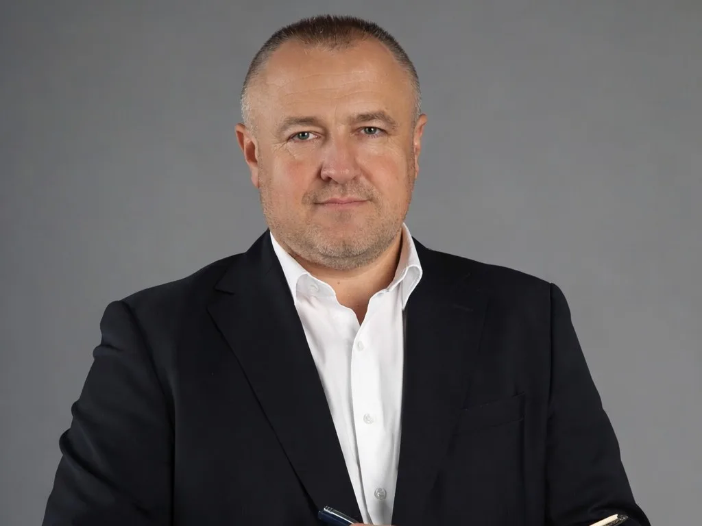 Чоловік у діловому костюмі на сірому тлі