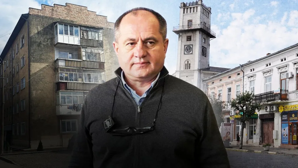 Чоловік стоїть на тлі міських будівель