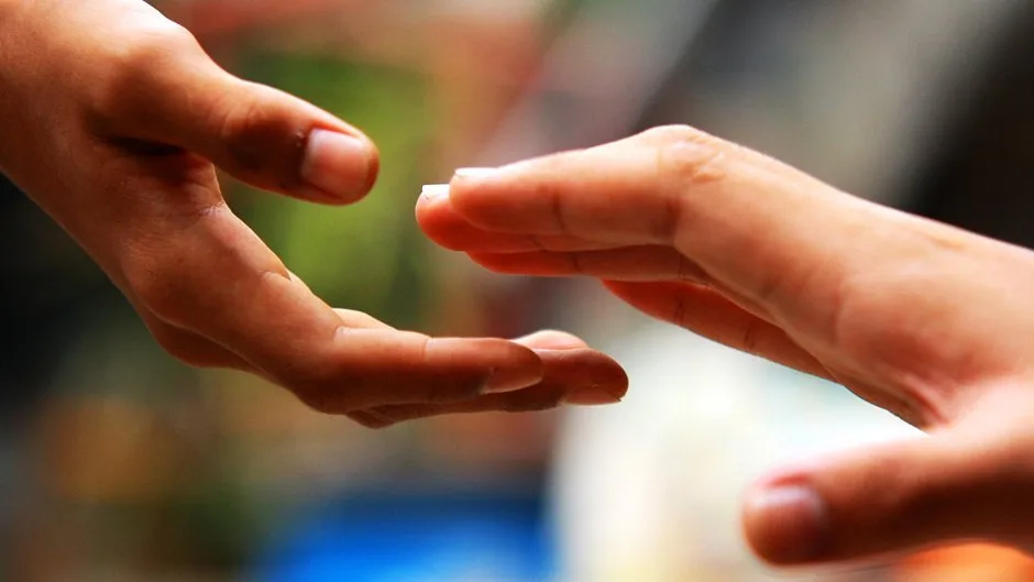Дві руки простягаються одна до одної