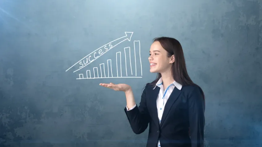 Бізнесвумен показує зростання успіху на графіку