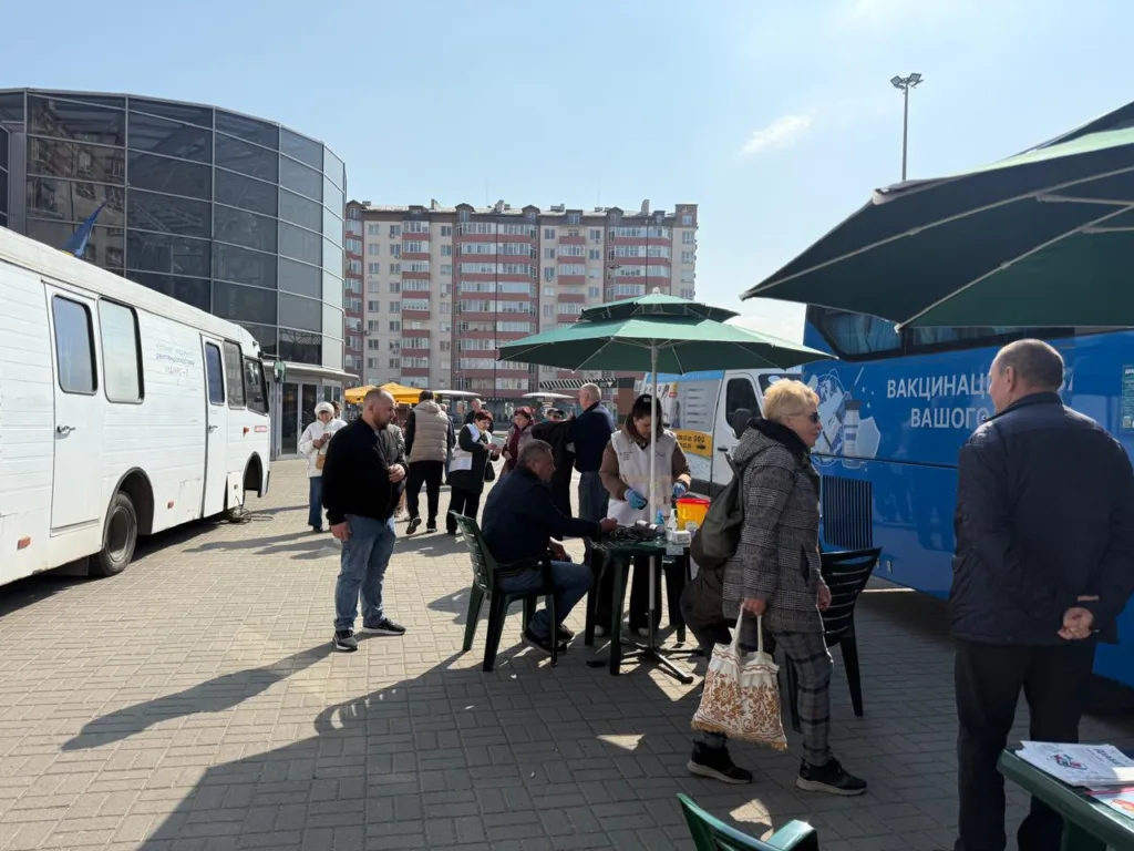 Люди біля мобільного пункту вакцинації на вулиці