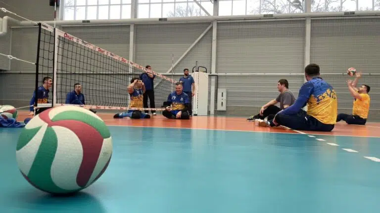 Гравці сидячого волейболу тренуються у спортзалі