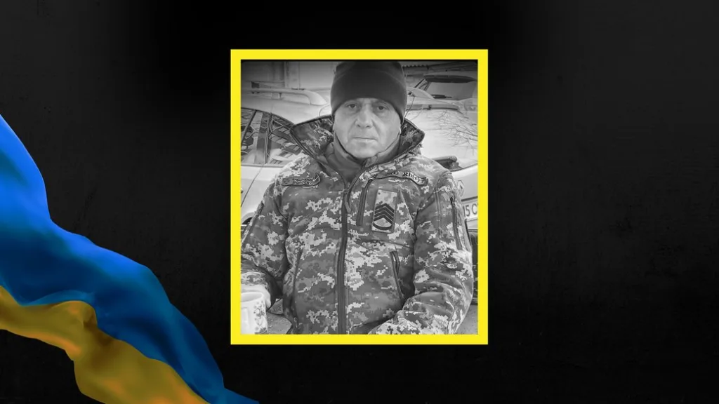 Український військовий у камуфляжі сидить на вулиці