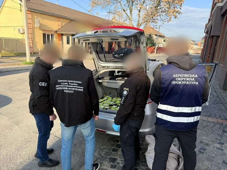 Правоохоронці оглядають вміст багажника автомобіля