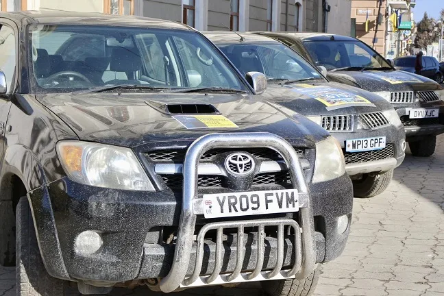 Ряд чорних позашляховиків на міській вулиці