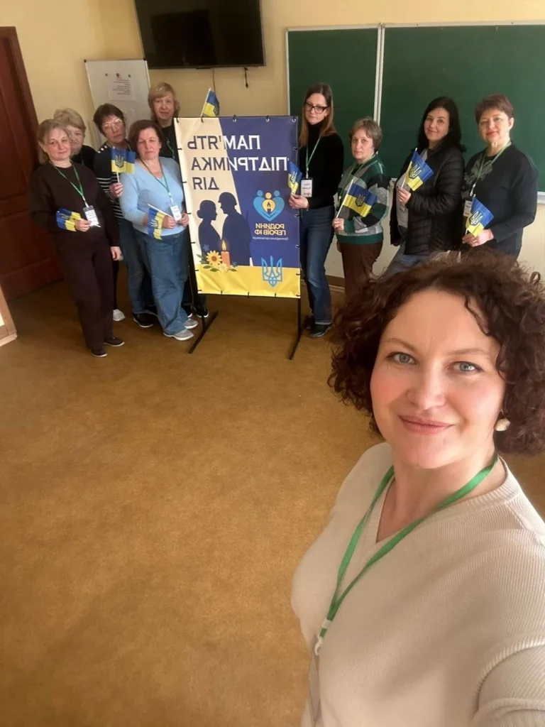 Група людей з українськими прапорами у класі