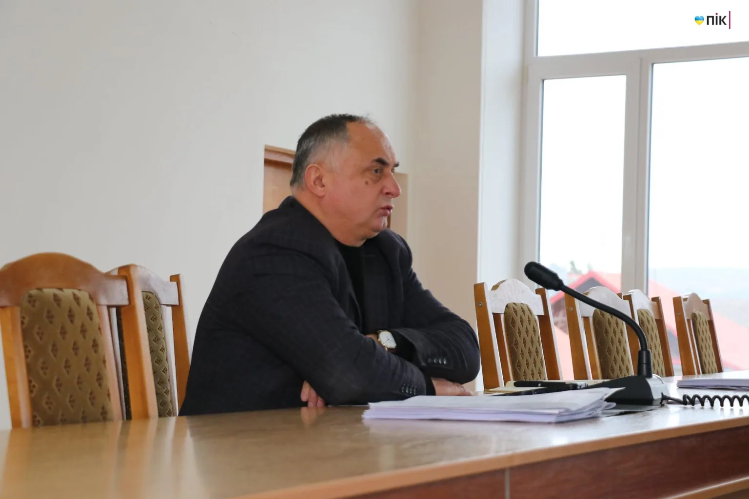 Чоловік говорить на нараді за столом