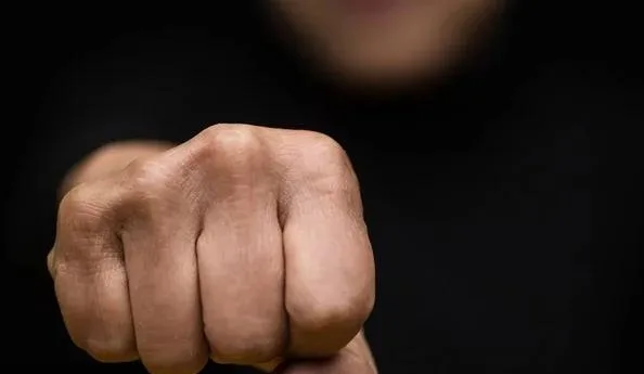 Стиснутий кулак крупним планом на темному фоні