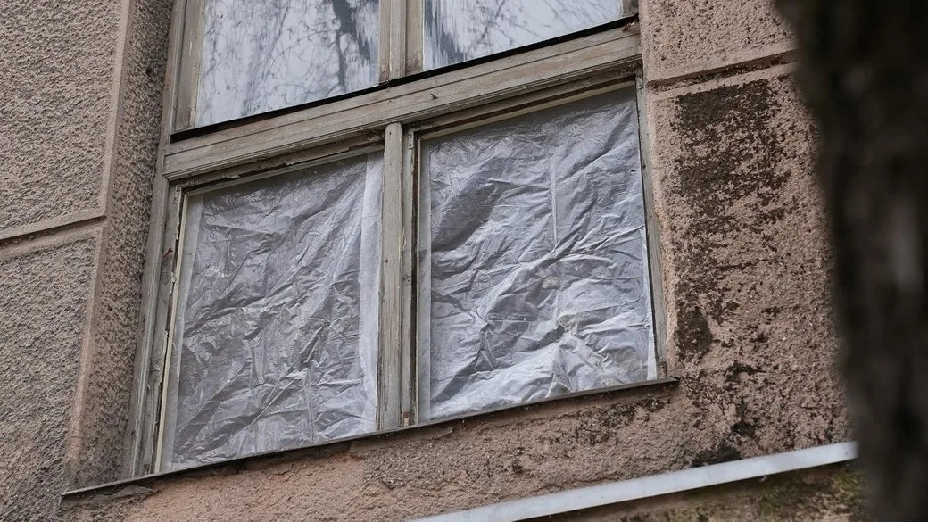 Вікно будинку закрите поліетиленовою плівкою
