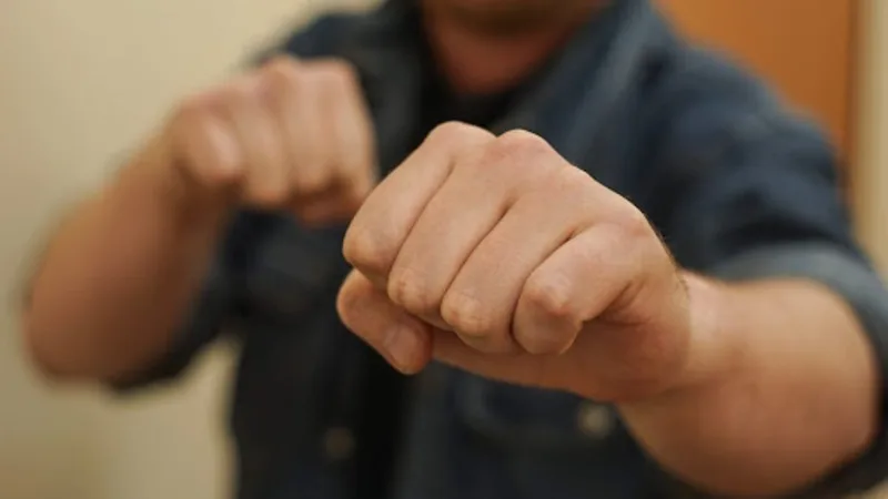Людина тримає стиснуті кулаки перед собою
