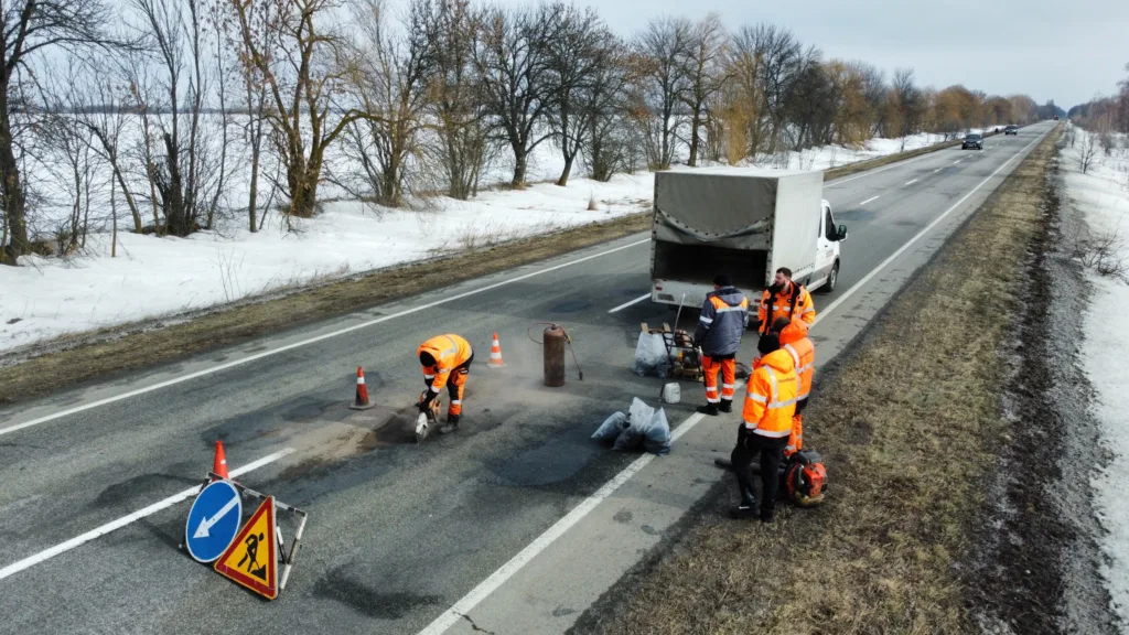 Робітники ремонтують дорогу взимку