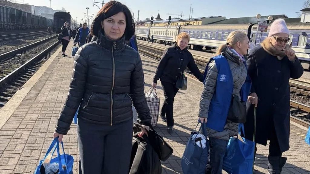 Люди з сумками на залізничній платформі