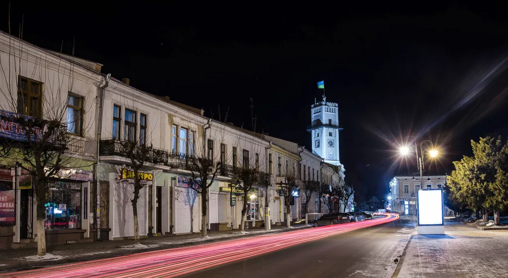 Нічне місто з ратушею та підсвіченою вулицею