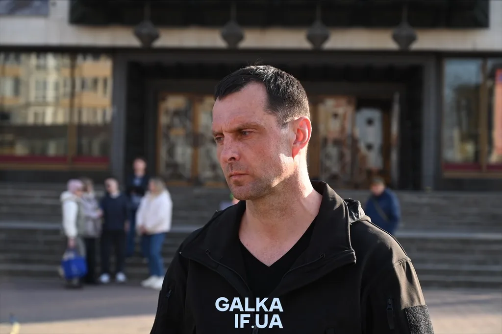 Чоловік стоїть перед будівлею в місті