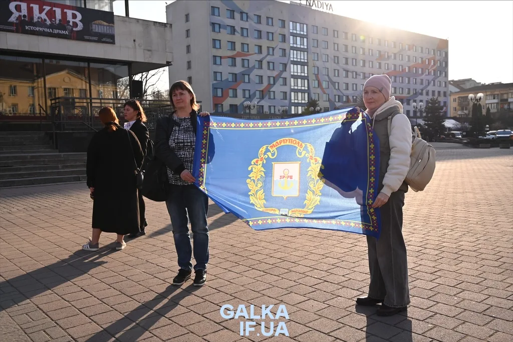 Жінки тримають прапор Маріуполя на площі