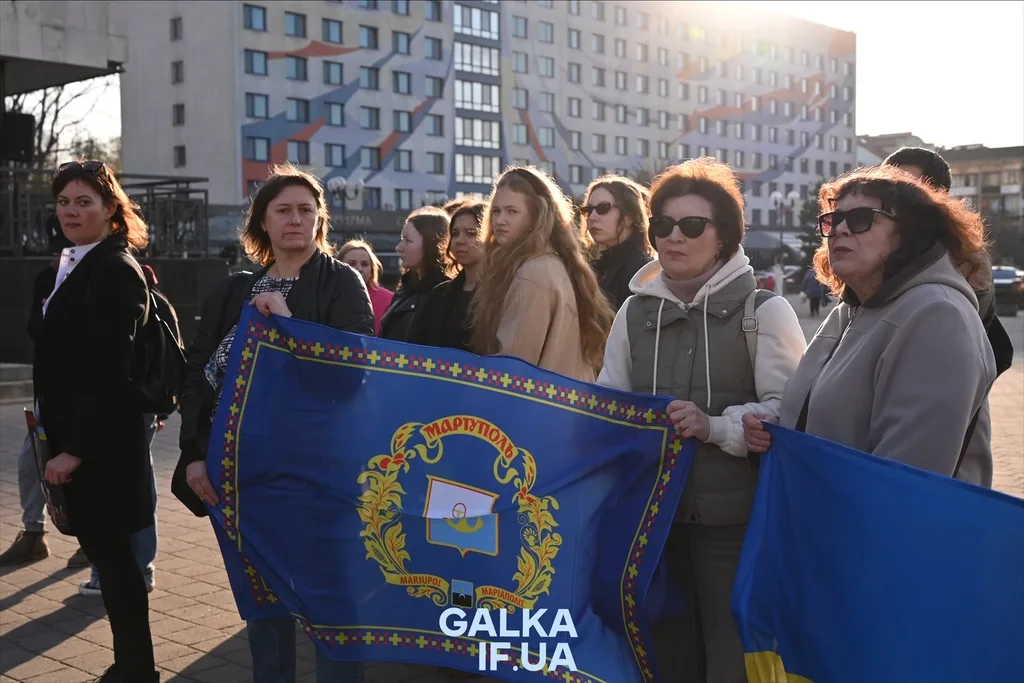Жінки тримають прапор Маріуполя на мітингу