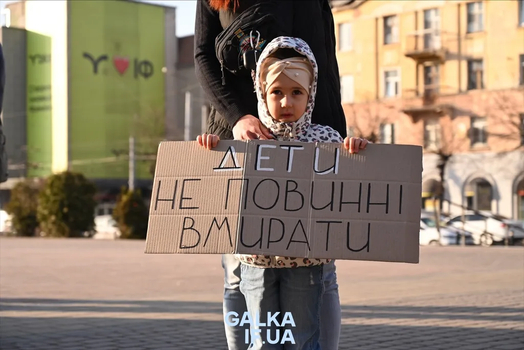 Дитина тримає плакат проти насильства над дітьми