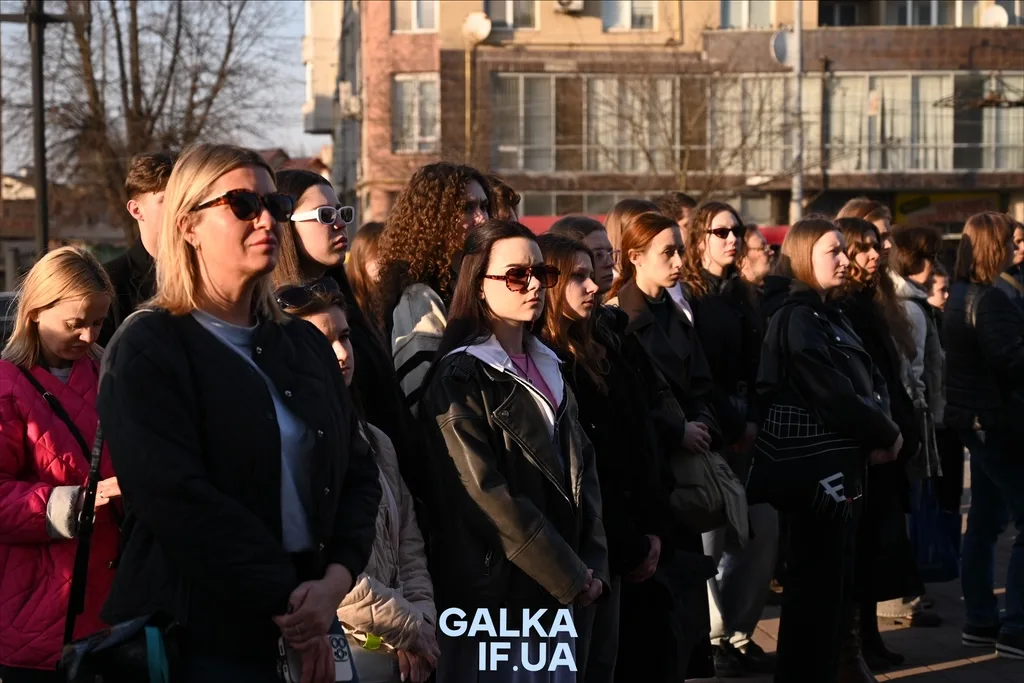 Люди стоять на вулиці під час заходу