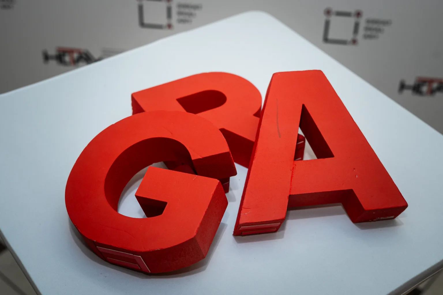 Червоні тривимірні літери на білому столі