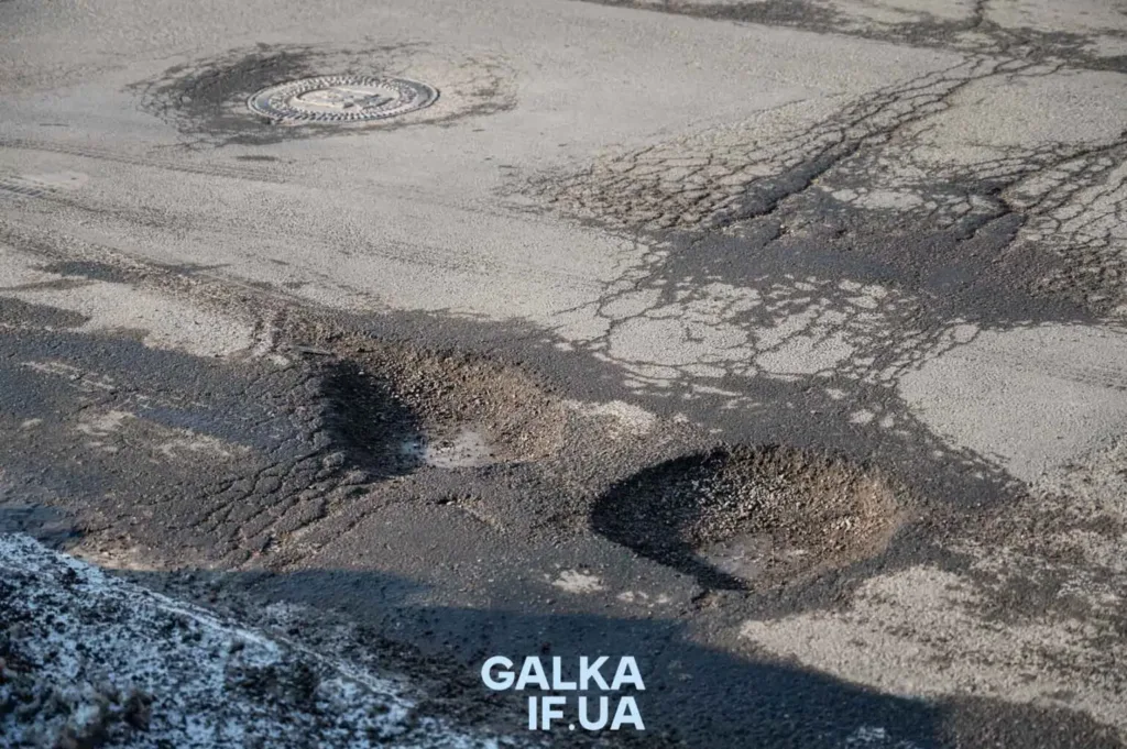 Пошкоджена дорога з ямами та тріщинами