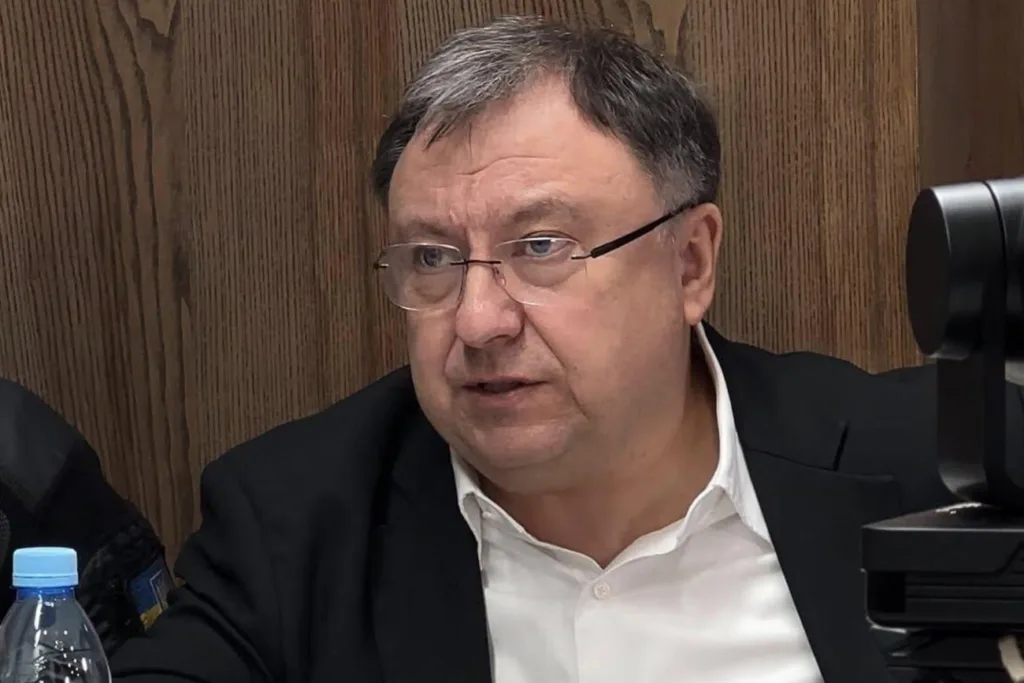 Чоловік у костюмі сидить за столом