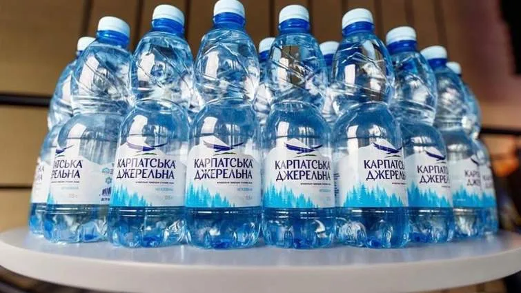 Пляшки Карпатської Джерельної мінеральної води на столику