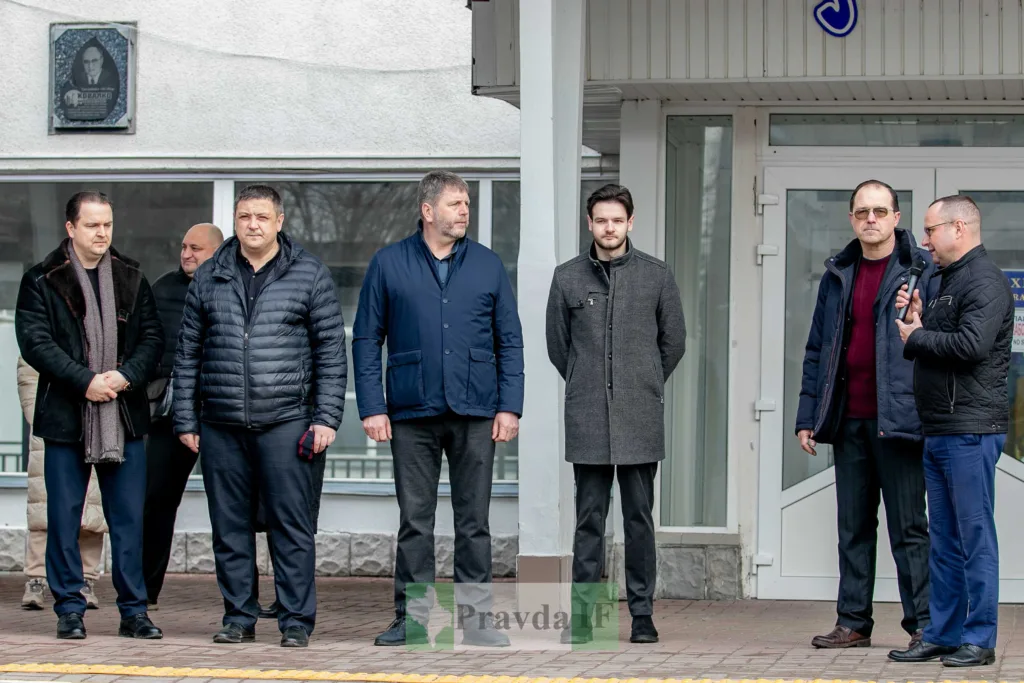 Група чоловіків стоїть перед будівлею