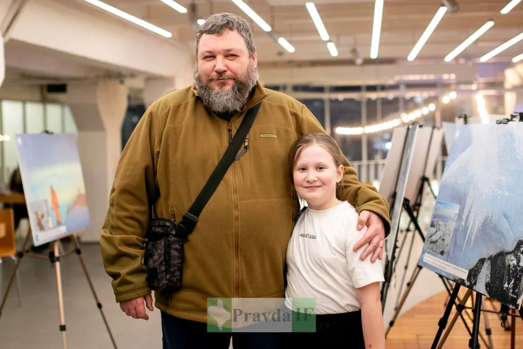 Чоловік і дівчинка на фотовиставці у галереї