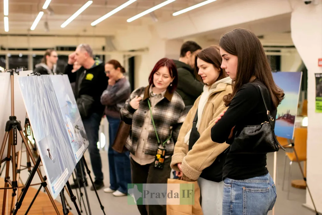 Люди оглядають картини на виставці мистецтва