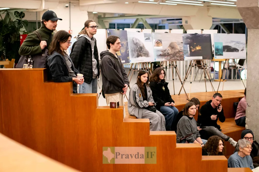 Люди відвідують фотовиставку в сучасній галереї