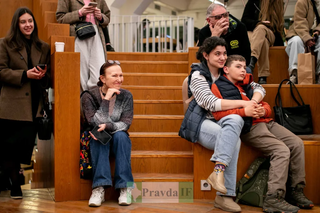 Люди сидять на дерев'яних сходах під час події