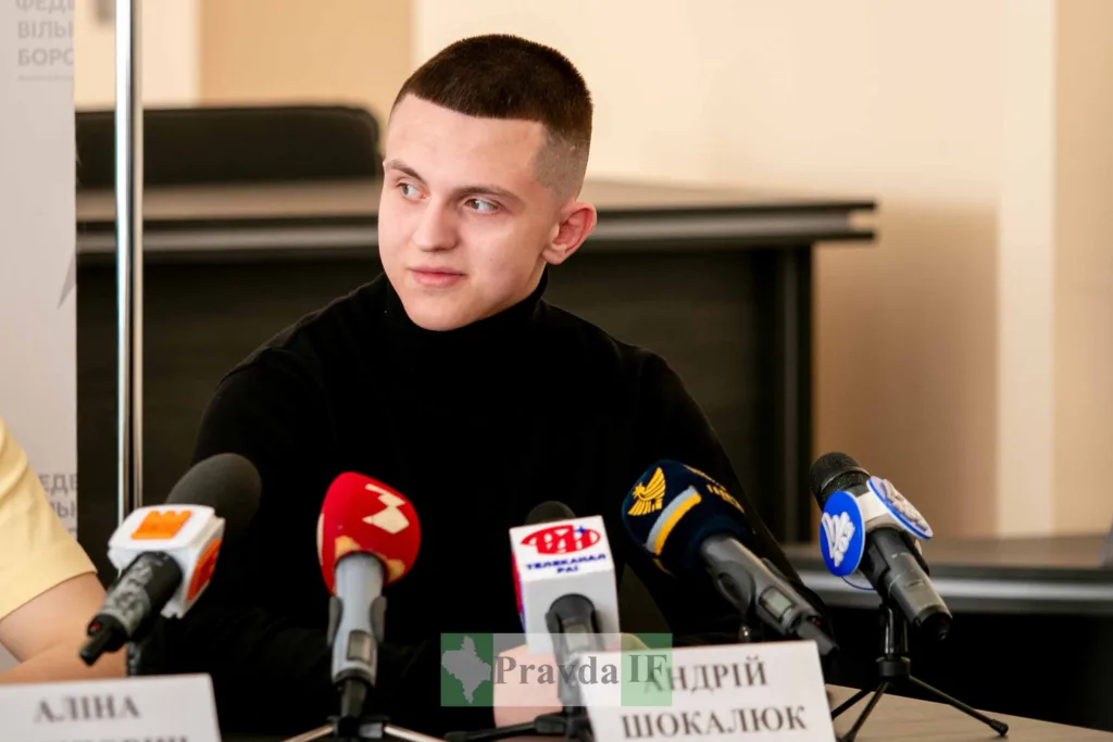 Молодий чоловік на пресконференції з мікрофонами