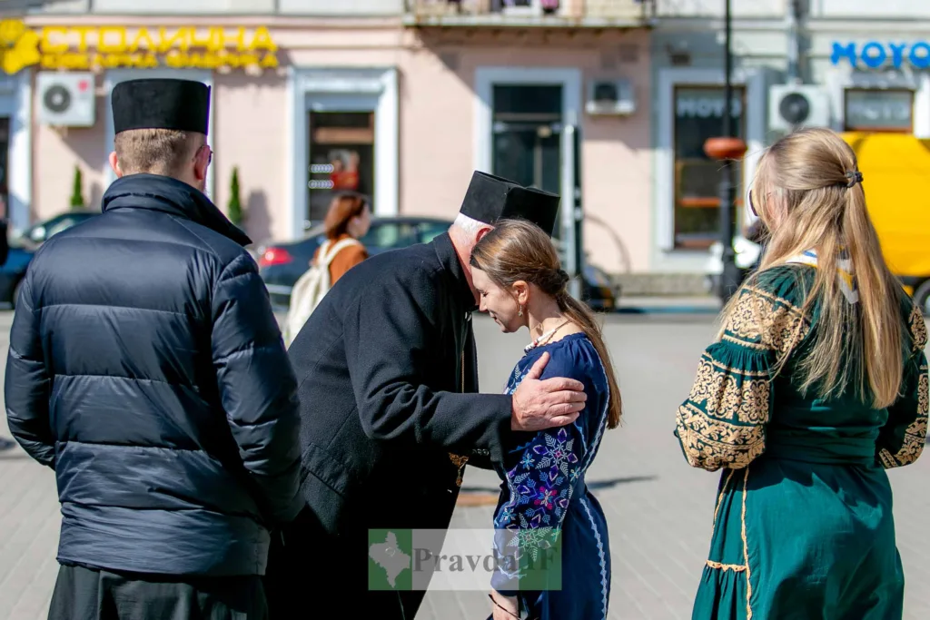 Священник благословляє жінку у вишиванці на вулиці