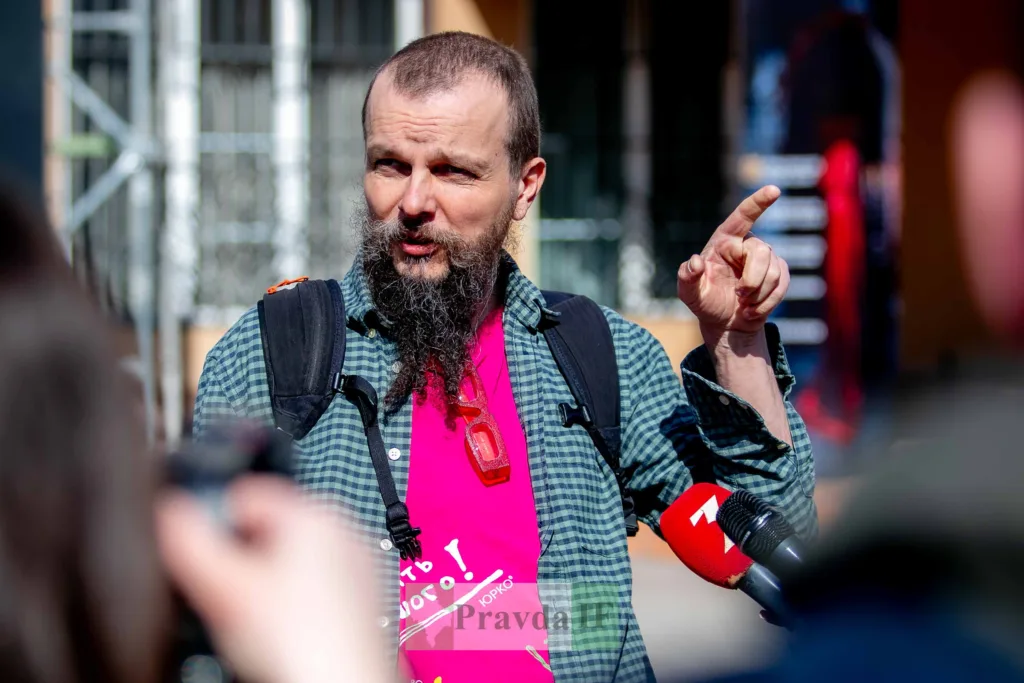 Чоловік з мікрофоном відповідає журналістам на вулиці