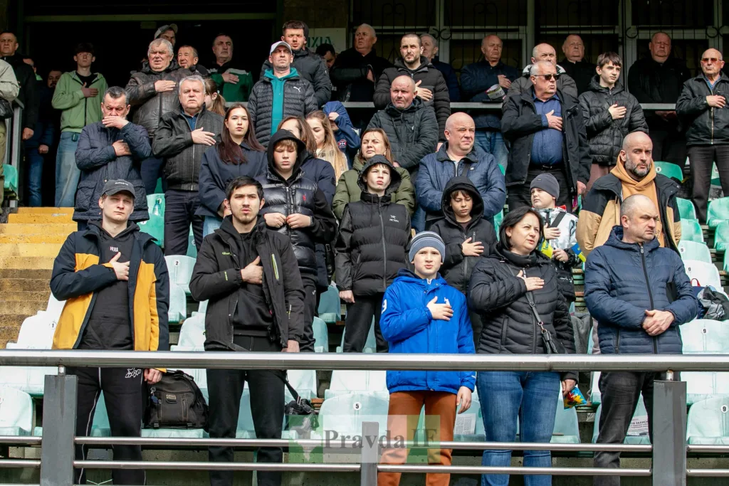 Люди стоять на трибуні зі щирими серцями.