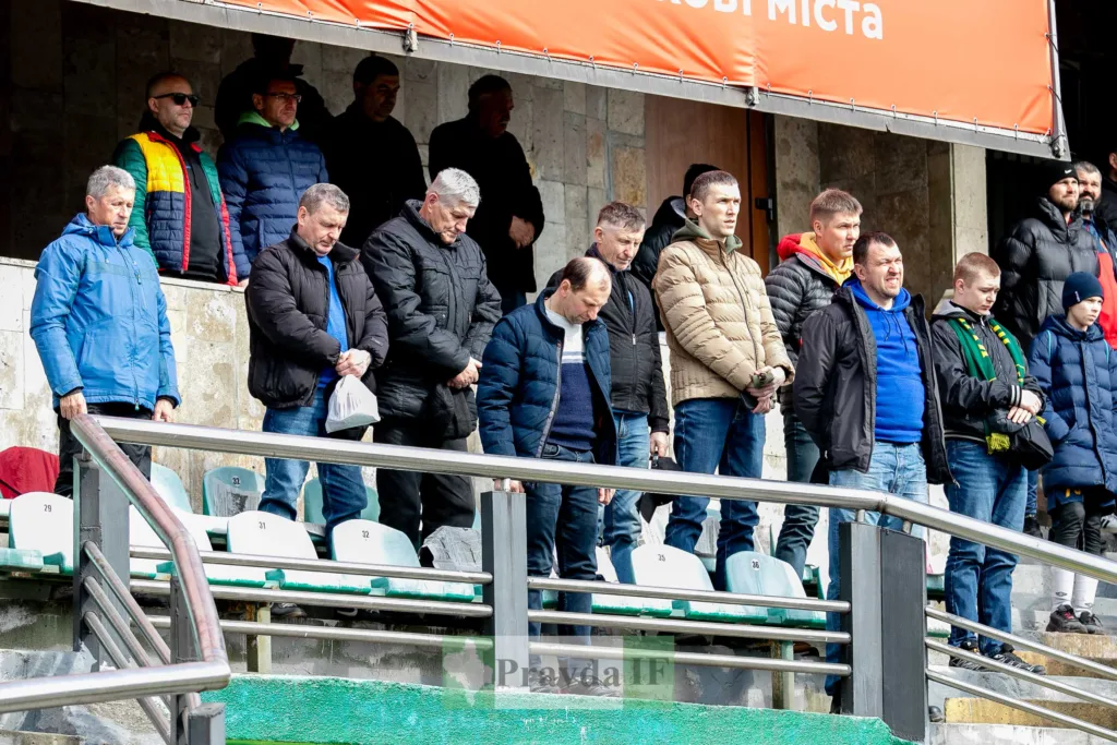 Уболівальники стоять на трибуні футбольного стадіону