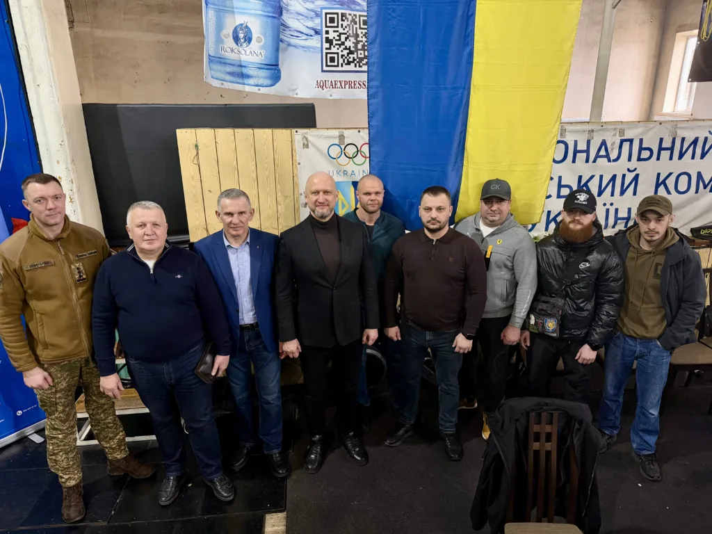 Група чоловіків перед прапором України