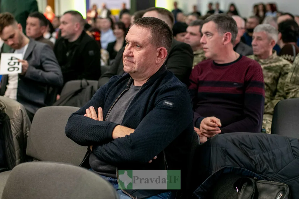 Чоловіки на публічному заході сидять у залі