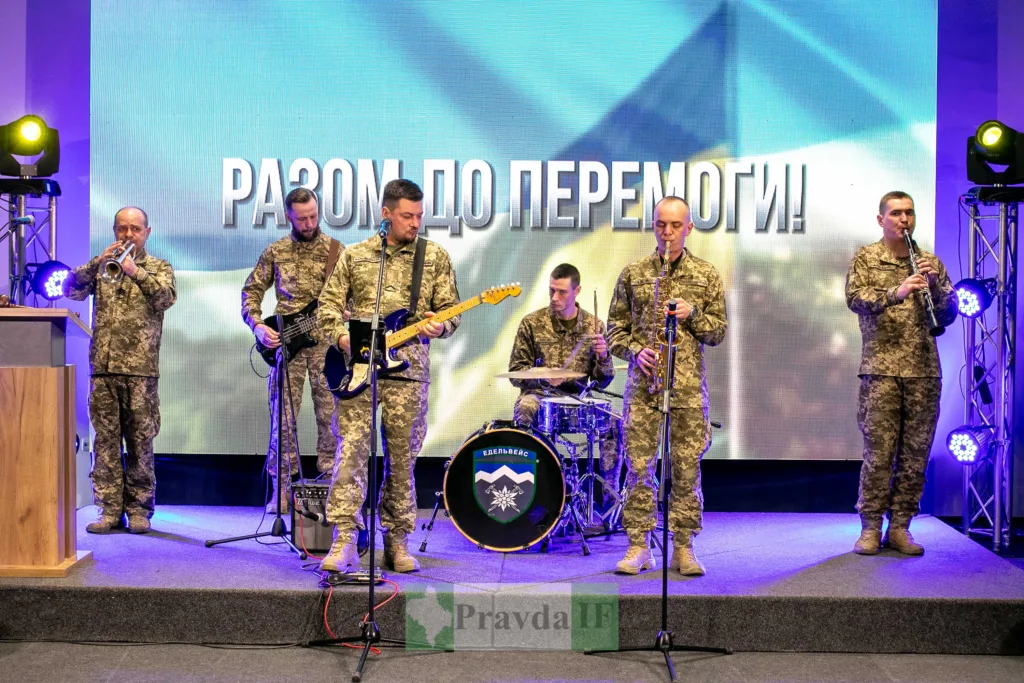 Військовий оркестр виступає на сцені з прапором України