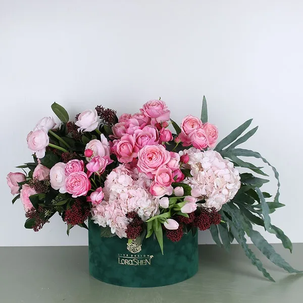 Букет рожевих квітів у зеленій коробці