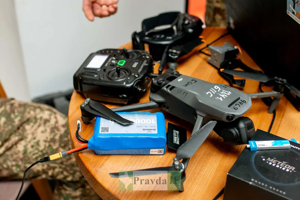 Дрон із пультом і батареєю на столі