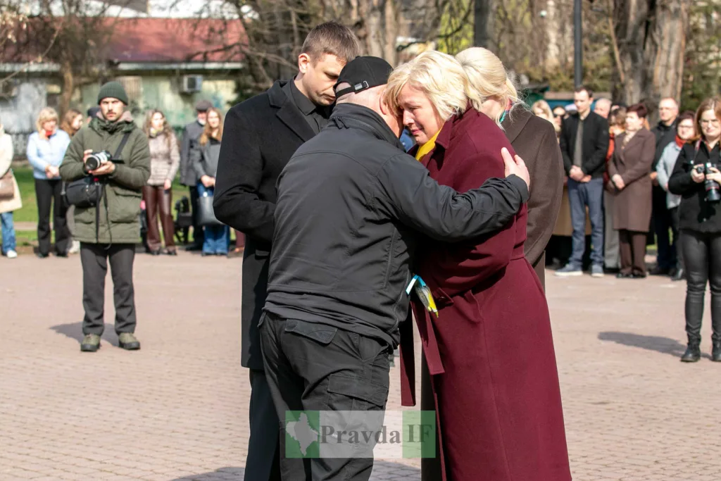 Люди обіймаються під час жалобної церемонії