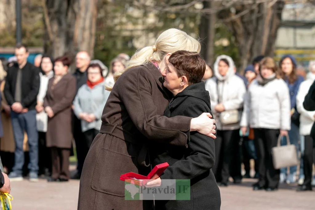 Жінки обіймаються під час публічної церемонії