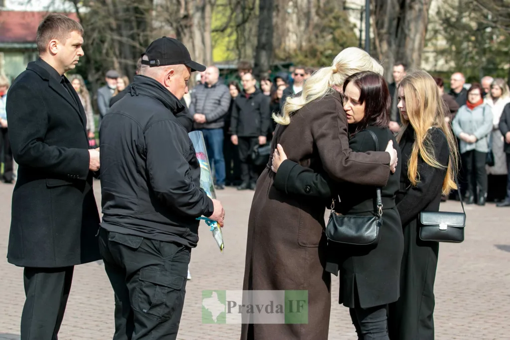 Люди обіймаються та сумують під час церемонії