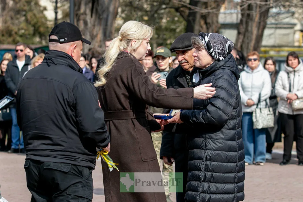 Жінка вручає нагороду літнім людям на церемонії