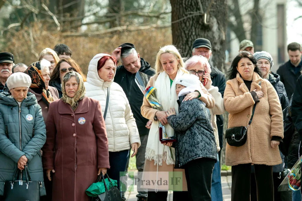 Люди сумують під час пам'ятного заходу на вулиці